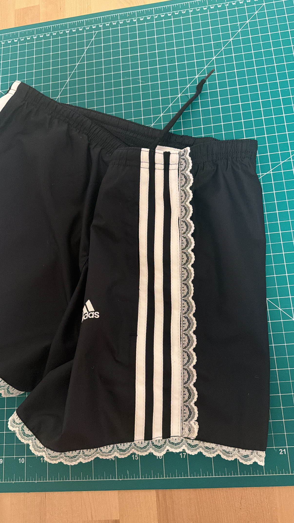 Close-up of the lace trim added along the side seam next to the Adidas stripes